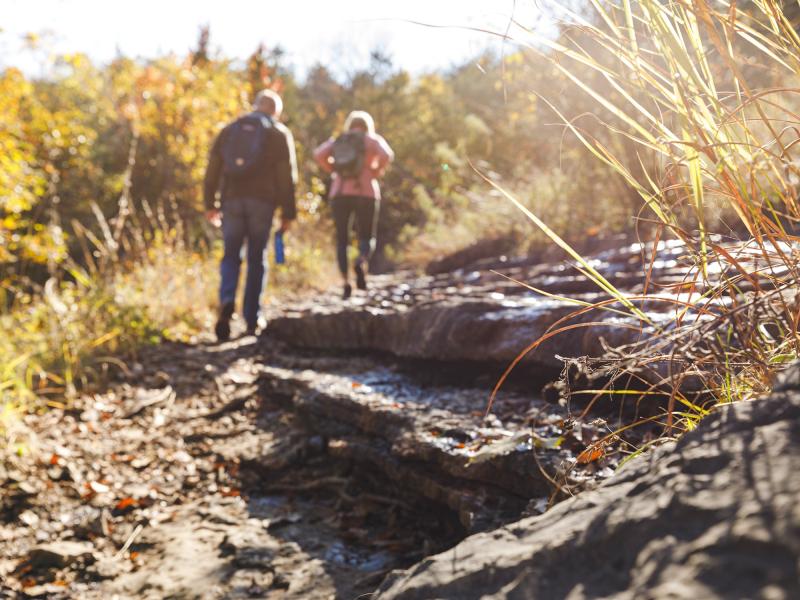 Man and woman standing of the edge of a rock ledge during a scenic hike in Branson.