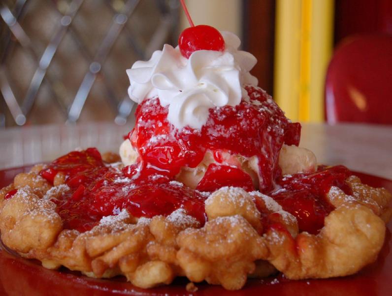 Cakes n Creams golden funnel cake with ice cream and a cherry on top