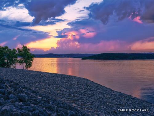 Beginning at the shore line, the image expands to display a sky full of oranges, purples and blues as the sun finishes setting for the evening. The dancing colors in the sky are reflected in the Table Rock Lake water.