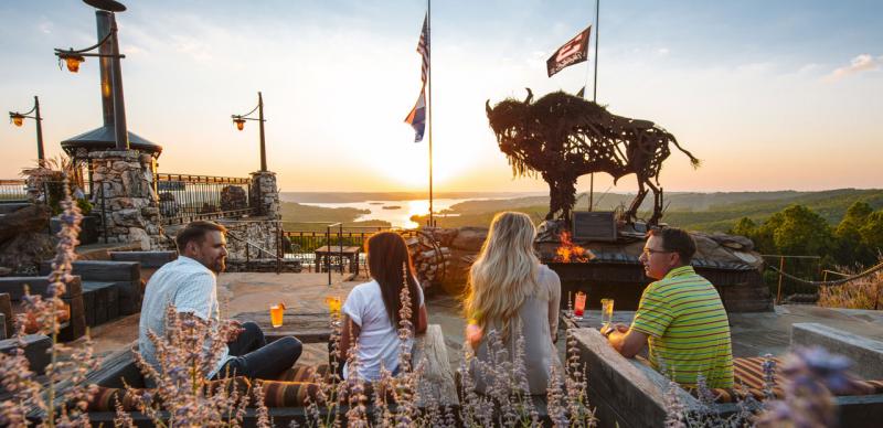 Two couples on a date at an upscale restaurant in Branson that overlooks a lake and a sunset.