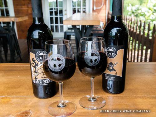 Two glasses of red wine and two full bottles of wine from Bear Creek Wine Company in Branson.
