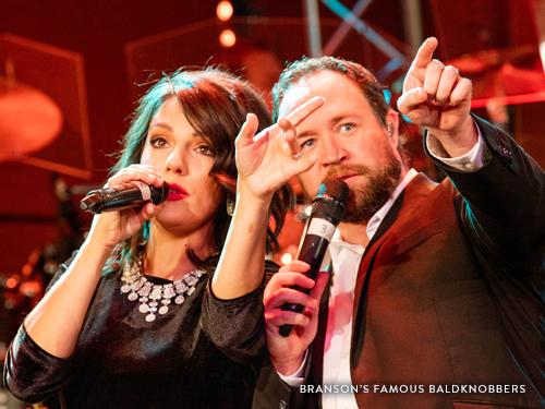 Husband and wife singing on a Branson live show stage.