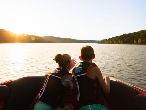 Brother and sister looking out at the lake from their family boat in Branson.