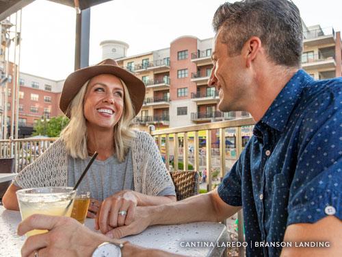 Couple holding hands during a meal at Branson Landing.