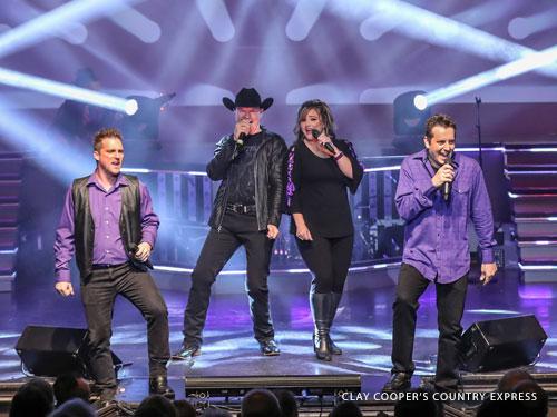 Country singer singing alongside cast of singers and dancers on a live show stage in Branson.