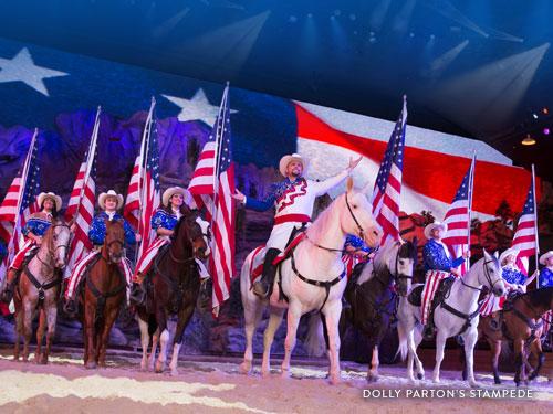 Artistas montando caballos y sosteniendo banderas estadounidenses en un show en vivo de Branson. 