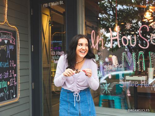 Girl laughing and eating an ice cream popsicle at Dreamsicles in Downtown Branson