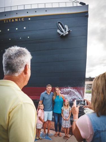 Grandparents taking pictures of their kids and grandkids in front of the Titanic Museum Attraction in Branson.