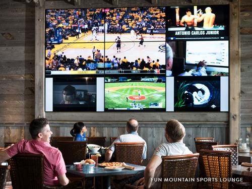 Group of men sitting in lounge watching sports game on the tv in Branson.