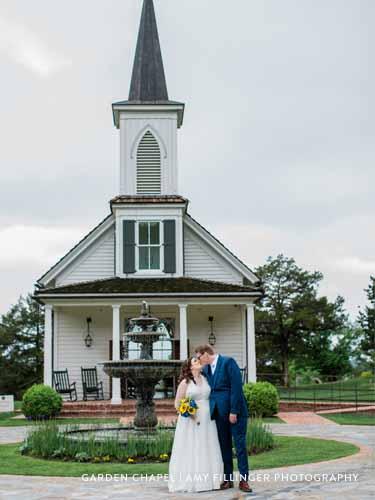 Newlywed couple kissing in front of the Garden Chapel and a large fountain at Big Cedar Lodge.
