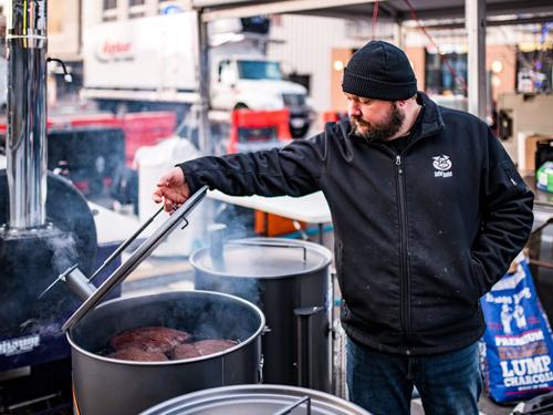 Man cooking barbecue in 55-gallon barrel in Branson.