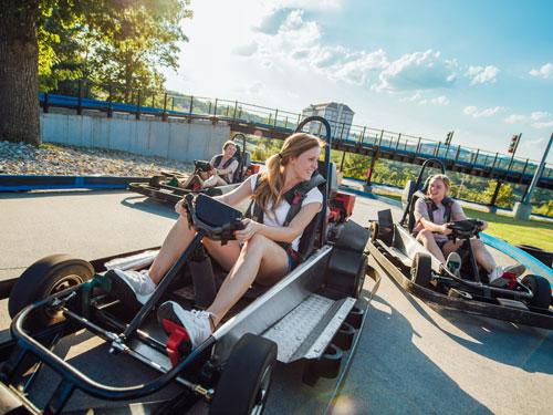 Three friends racing each other on go-karts in Branson.