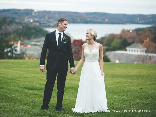 Recently married couple holding hands and smiling at each other in the middle of the Ozarks.