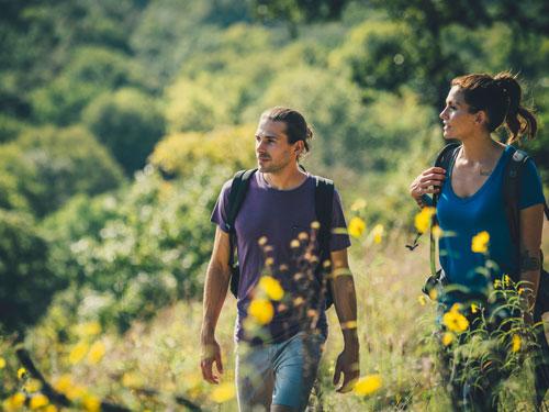 Young and fit man and woman walking on a scenic hiking trail in Branson.