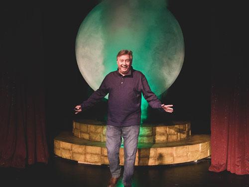 Man walking through smoke machine on Branson live show stage. 