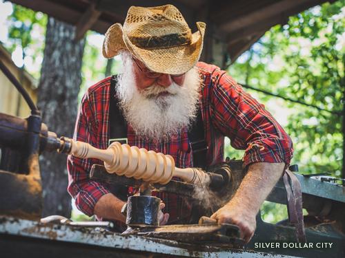 A craftsman at Silver Dollar City creating a wooden piece.