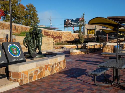 Picnic tables, stage, waterfall and Branson sign.