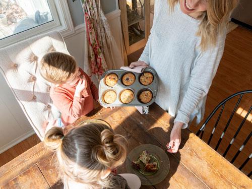 Mom serving her son and daughter homemade blueberry muffins inside a home in Branson.