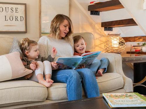 Mom reading her son and daughter a book from a living room in Branson. 