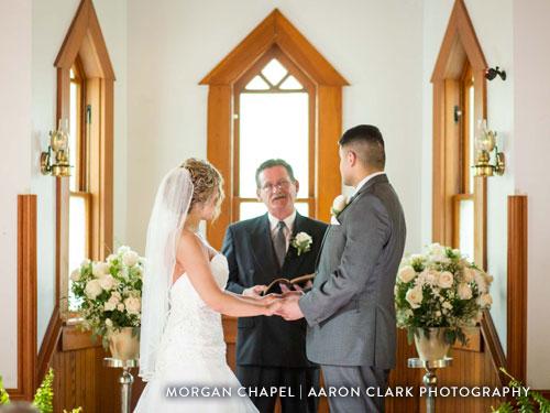Indoor chapel wedding venue. Couple standing at alter taking their vows.