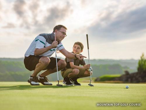 Father and son reading a putt on a golf course in Branson.