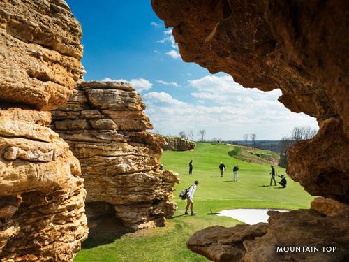 Golfers walking around green at scenic golf course on a mountain in Branson.