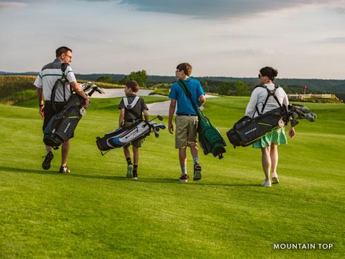 Group of four golfers walking on scenic Branson golf course.
