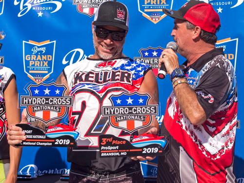 Man presenting trophy to winner of powerboat race in Branson.
