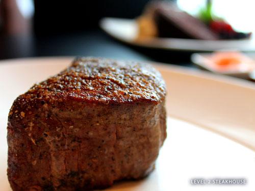 Thick steak being served on a white plate at an upscale restaurant in Branson.