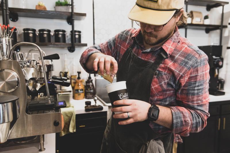 Man pouring coffee into a mug at a coffee shop in Branson. 