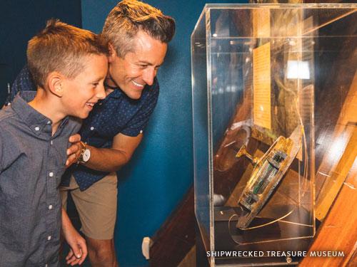 Father and son looking at an underwater treasure displayed in a museum in Branson.