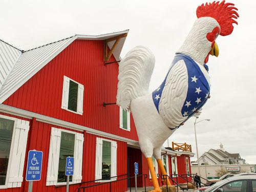 Oversized patriotic chicken in front of a red barn style chicken and steakhouse restaurant on the Branson Strip.