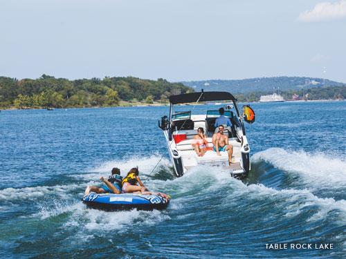 Family of four pulling a tube behind a speedboat in Branson.
