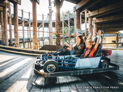 Mom and son riding a go-kart on a three story wooden track in Branson.