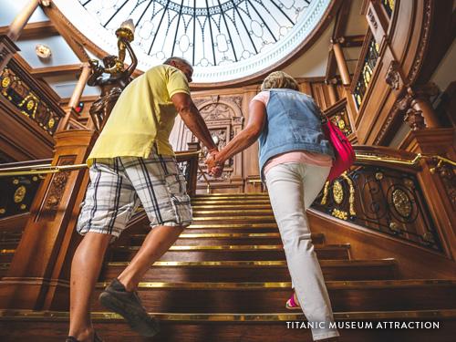 Couple holding hands and walking up a grand staircase at an interactive Titanic attraction in Branson.