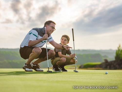 Father and son reading a putt on a golf course in Branson.