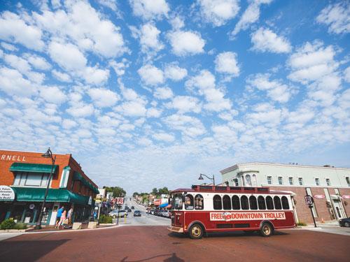 Free Downtown trolley driving in front of main street in Downtown Branson.