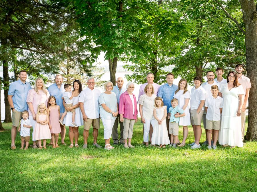 A joyful extended family portrait session near Table Rock Lake—coordinated in soft blues, pinks, and creams, surrounded by Branson’s lush greenery and timeless beauty.
