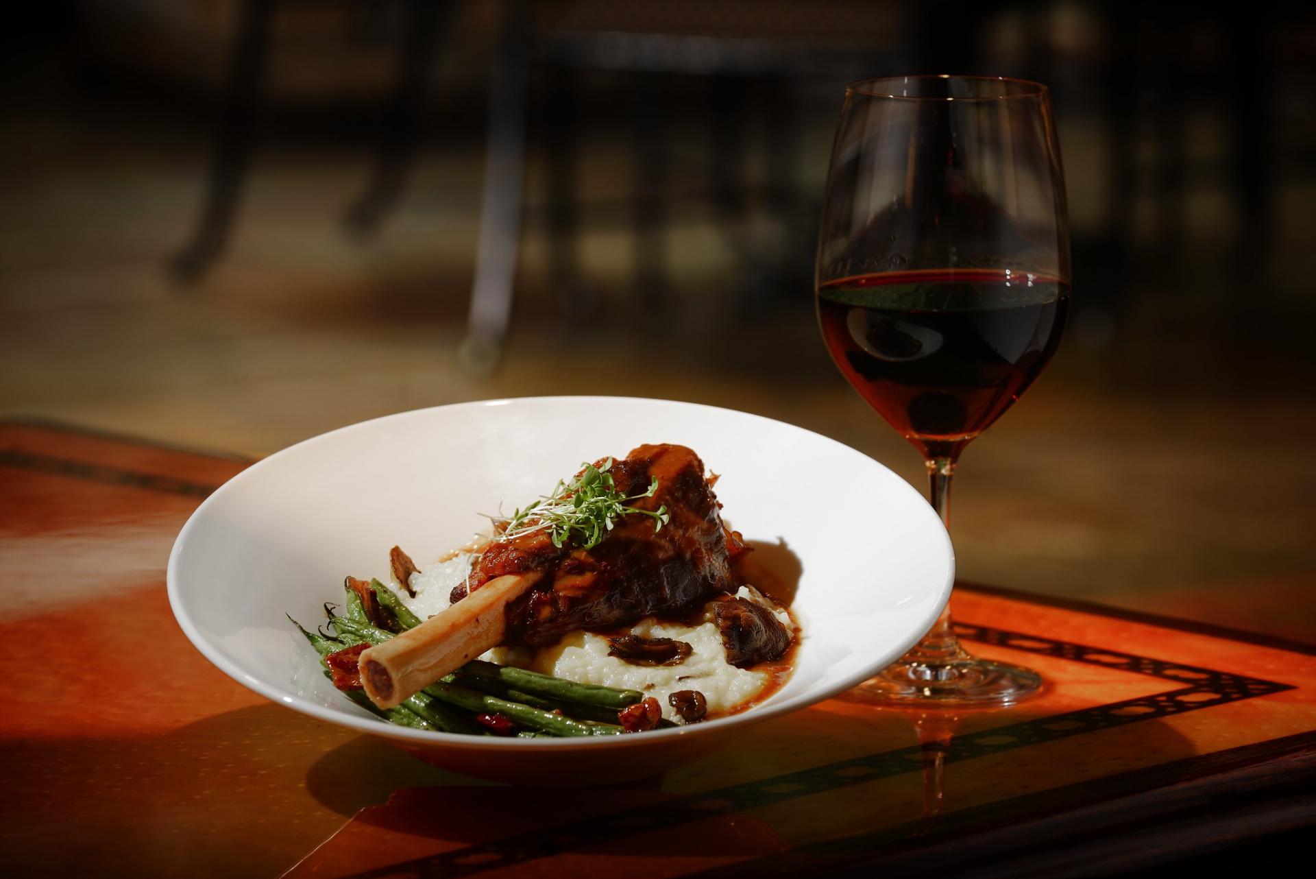 A plate of food with a glass of wine.