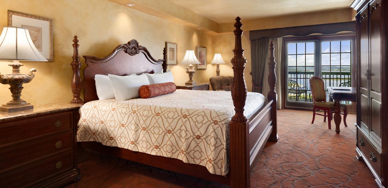 Spacious room with a king size bed and doors that open to a balcony. 