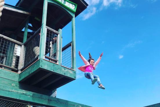 Little Girl Jumping of a platform at the Yeti Fun Zone & Monkey Jump