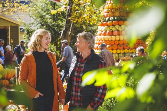 a couple smiling at each other walking through SDC's Harvest Festival