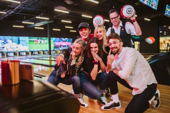 A group of friends pose for a photo at Andy B's Bowl Social