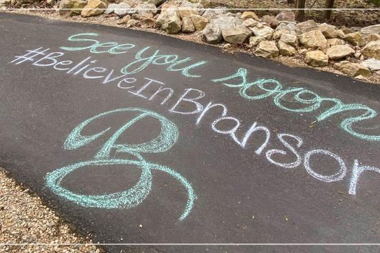 Chalk art of a Branson message on a local walking path. 