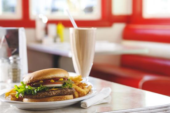 Hamburger, fries and a milkshake sitting on a table in a diner in Branson. 