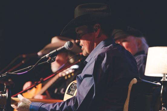 Three classic country live show performers singing country songs while wearing cowboy hats on a stage in Branson.