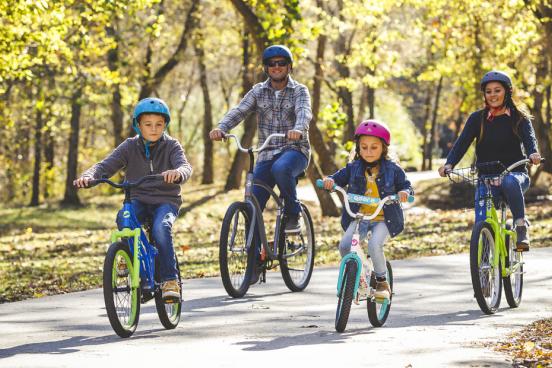 Family of four riding bikes at nature park in Branson. 