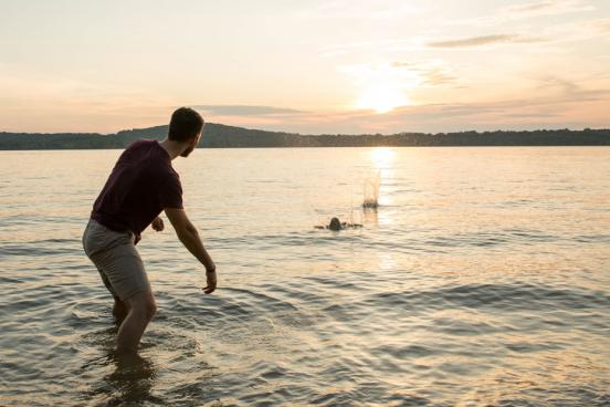 Guy skipping rocks toward the sunset on Table Rock Lake.