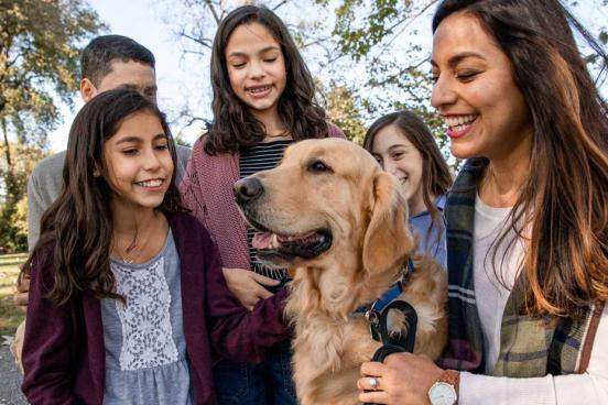 Family gathered around their golden retriever dog.