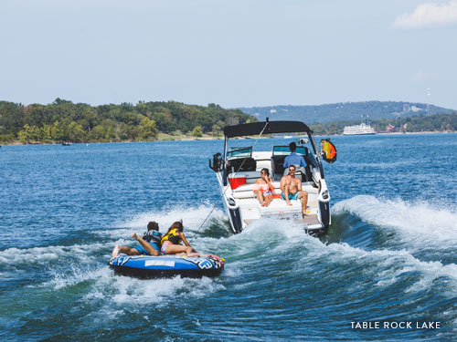 Family of four pulling a tube behind a speedboat in Branson.